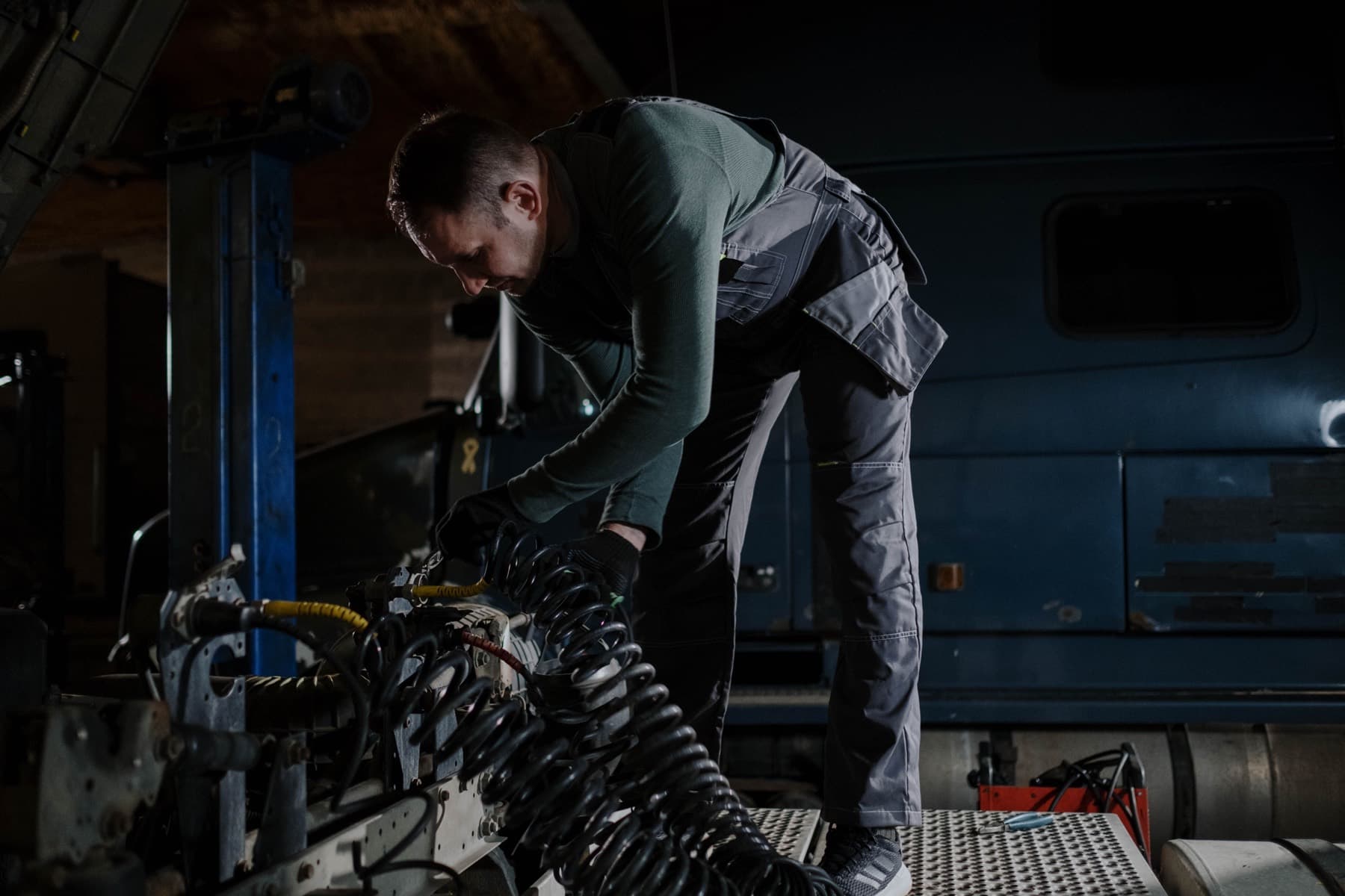 Technician working on a heavy-duty chassis late in the shop