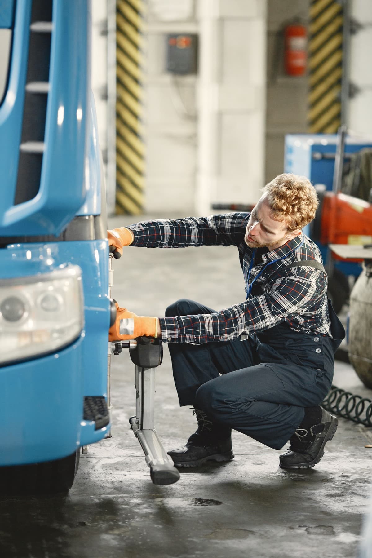 Technician working at the front of a truck inside the repair bay