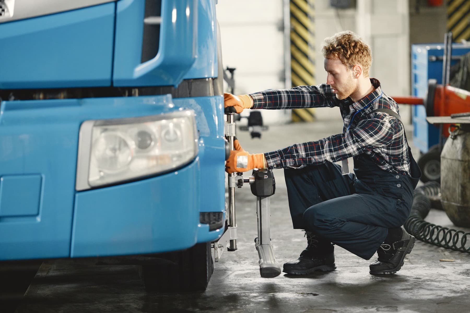 Technician servicing a wheel-end on a truck inside the repair bay